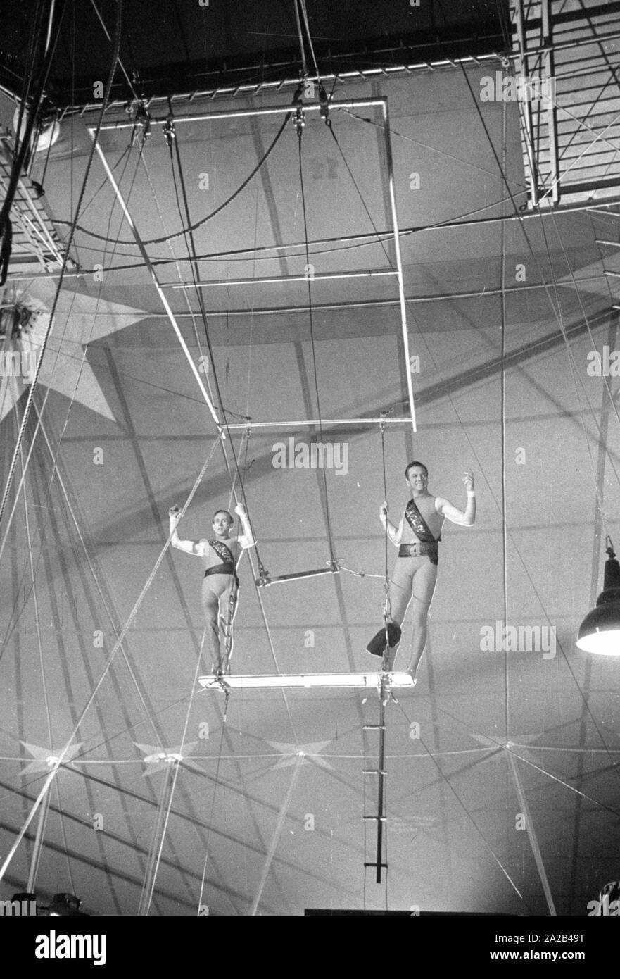 Shooting of the film "Koenig der Manege" with Rudolf Schock, Germaine Damar and Fritz Imhoff in the main roles. The picture shows Rudolf Schock (left) and Hans Putz as acrobats. High above in the circus tent, they rehearse for an artistic performance. Stock Photo