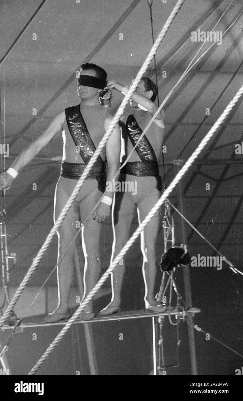 Shooting of the film 'Koenig der Manege' with Rudolf Schock, Germaine Damar and Fritz Imhoff in the main roles. The picture shows Rudolf Schock (left) and Hans Putz as acrobats. High above in the circus tent, they rehearse for an artistic performance. Stock Photo