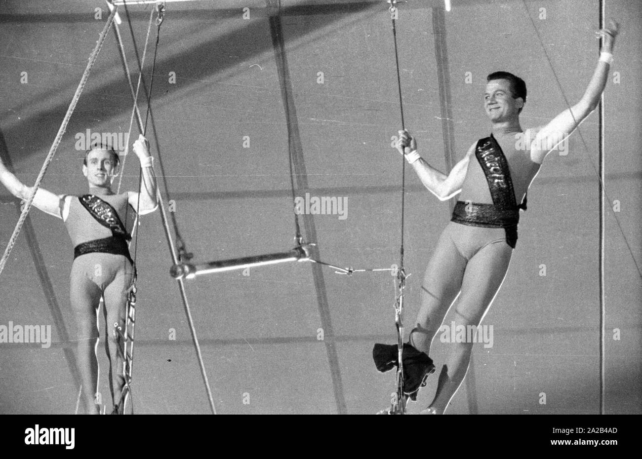 Shooting of the film 'Koenig der Manege' with Rudolf Schock, Germaine Damar and Fritz Imhoff in the main roles. The picture shows Rudolf Schock (right) and Hans Putz as acrobats. High above in the circus tent, they practice for an artistic performance. Stock Photo