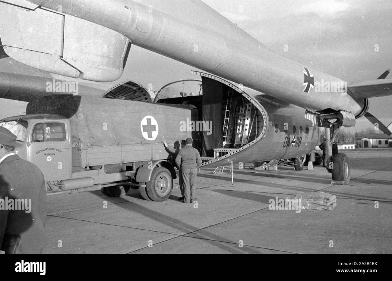 A Noratlas of the Bundesluftwaffen is loaded with auxiliary material destined for Morocco on the Neubiberg Air Base. During a so-called paralysis epidemic in Morocco, a Nord Noratlas aircraft of the Lufttransportgeschwader 61 of the Bundeswehr transports auxiliary material, including beds, to Morocco. Due to the operating range of the engine, the flights went via Madrid and Gibraltar to Africa. The cause of the paralysis epidemic was poisoned cooking oil (tri-acryl-phosphorus poisoning) which the patients partook at the Mouloud festival. Stock Photo