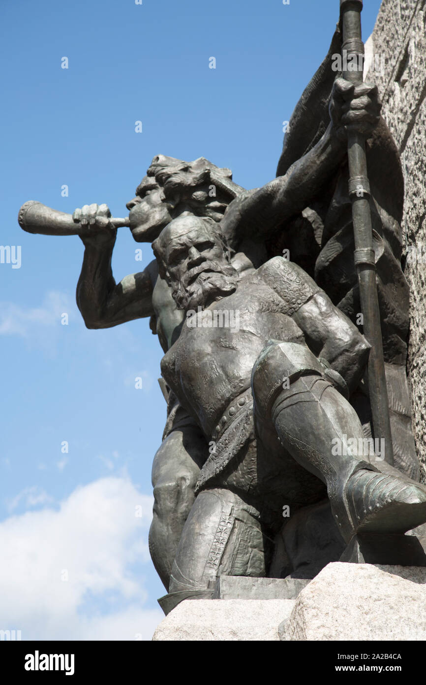 Lithuanian warrior blowing a horn and leading a captured Teutonic knight. The Grunwald Monument, location Matejko Square, Krakow, Poland Stock Photo