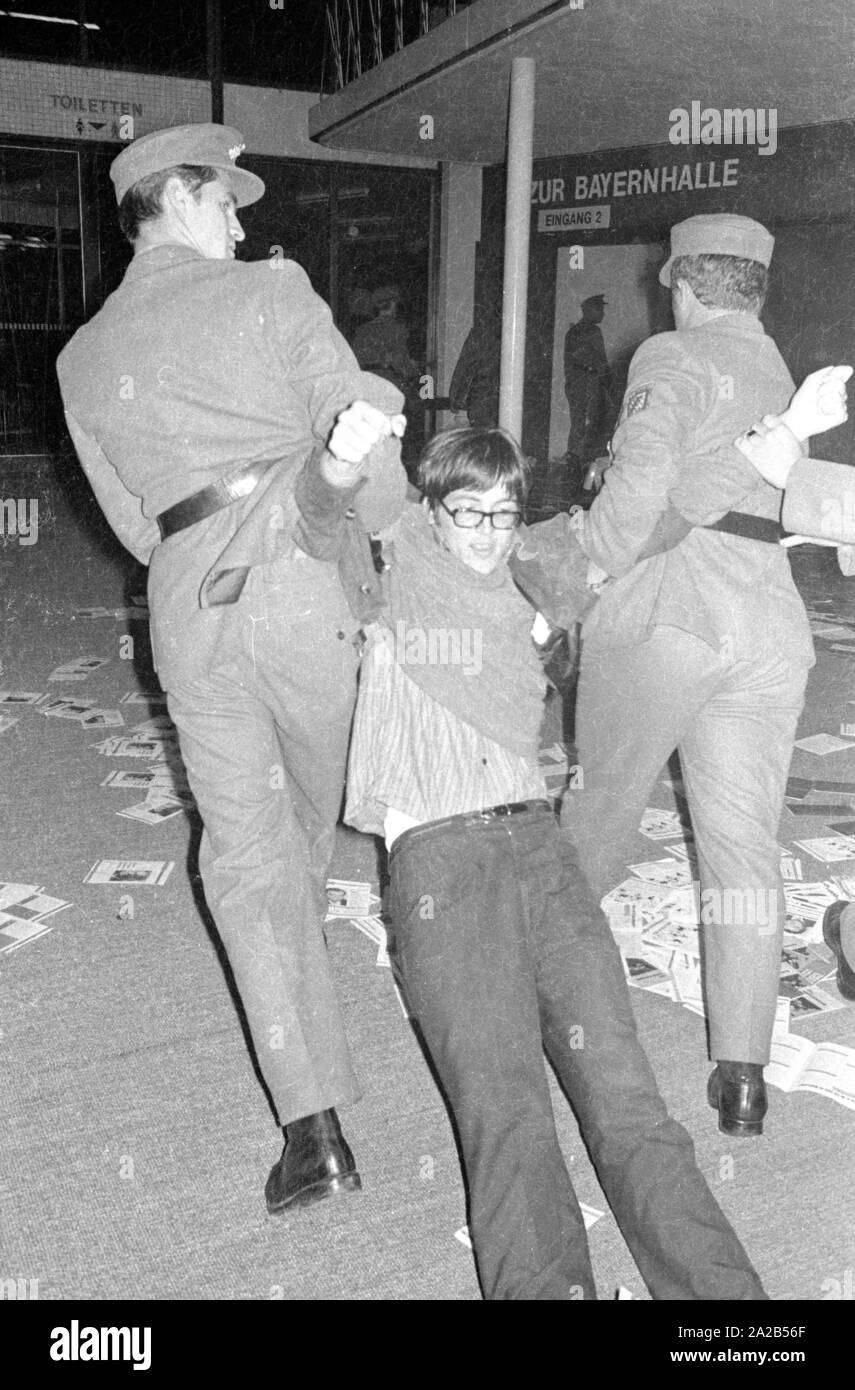 Members of the Ausserparlamentarische Opposition (extra-parliamentary opposition APO) gained access to an election campaign of the CSU with forged tickets in the Bayernhalle in Munich. Photo of policemen removing a member of the APO from the Bayernhalle. Stock Photo