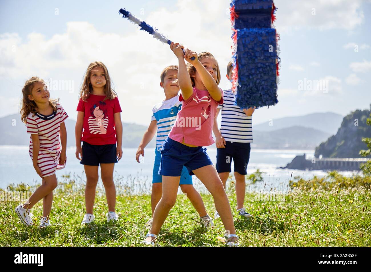 Children striking an anchor-shaped piñata, Getaria, Gipuzkoa, Basque Country, Spain Stock Photo