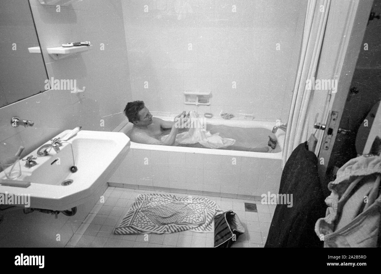 A man washes clothes in a bathtub. From the report "Earthquake in