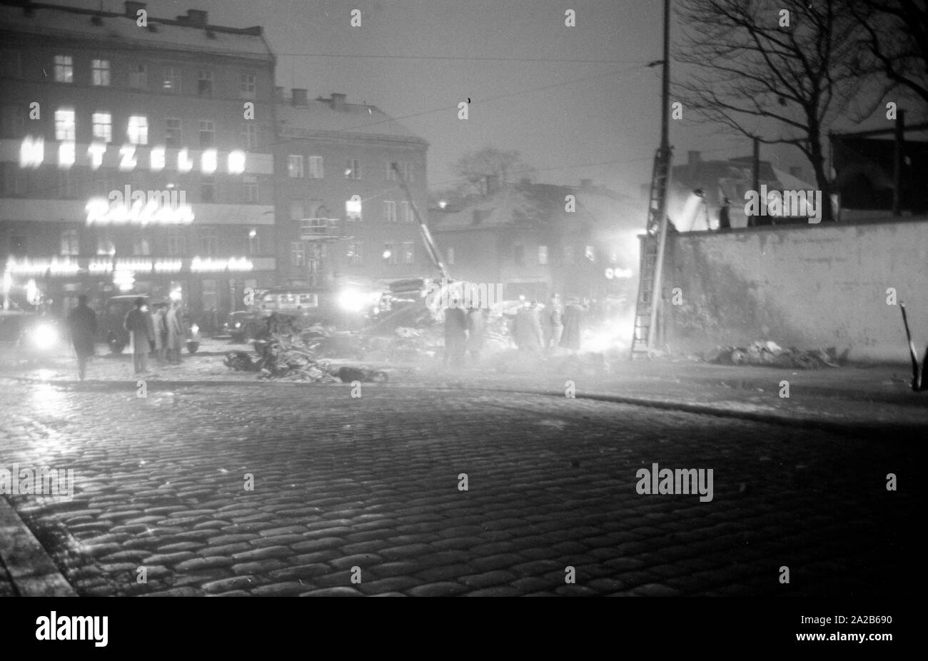 Shortly after the take off from the Munich-Riem Airport a US Air Force transport aircraft of the type Convair C-131-D Samaritan crashed in the area of Bayerstrasse / Martin-Greif Strasse on a tram. 52 people were killed. The picture shows the crash site illuminated with headlights, onlookers and wreckage. Stock Photo