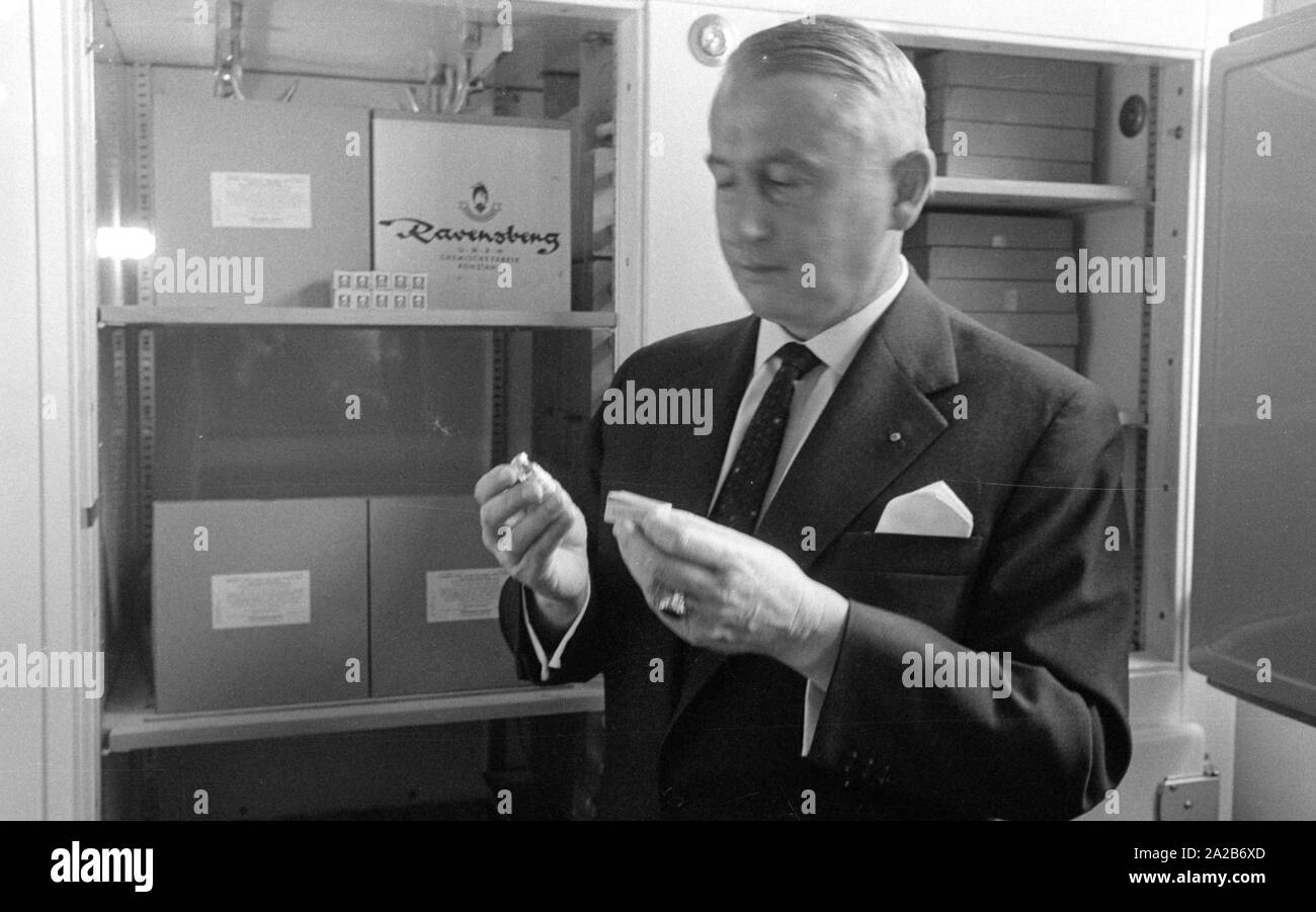 Immunization action in Konstanz with a newly developed flu vaccine of the Ravensberg Chemische Fabrik, an employee of the factory with the new active agent in front of a medicine cupboard. Around 1960 committees recommended the vaccination against influenza viruses for the first time in the Federal Republic of Germany. Stock Photo