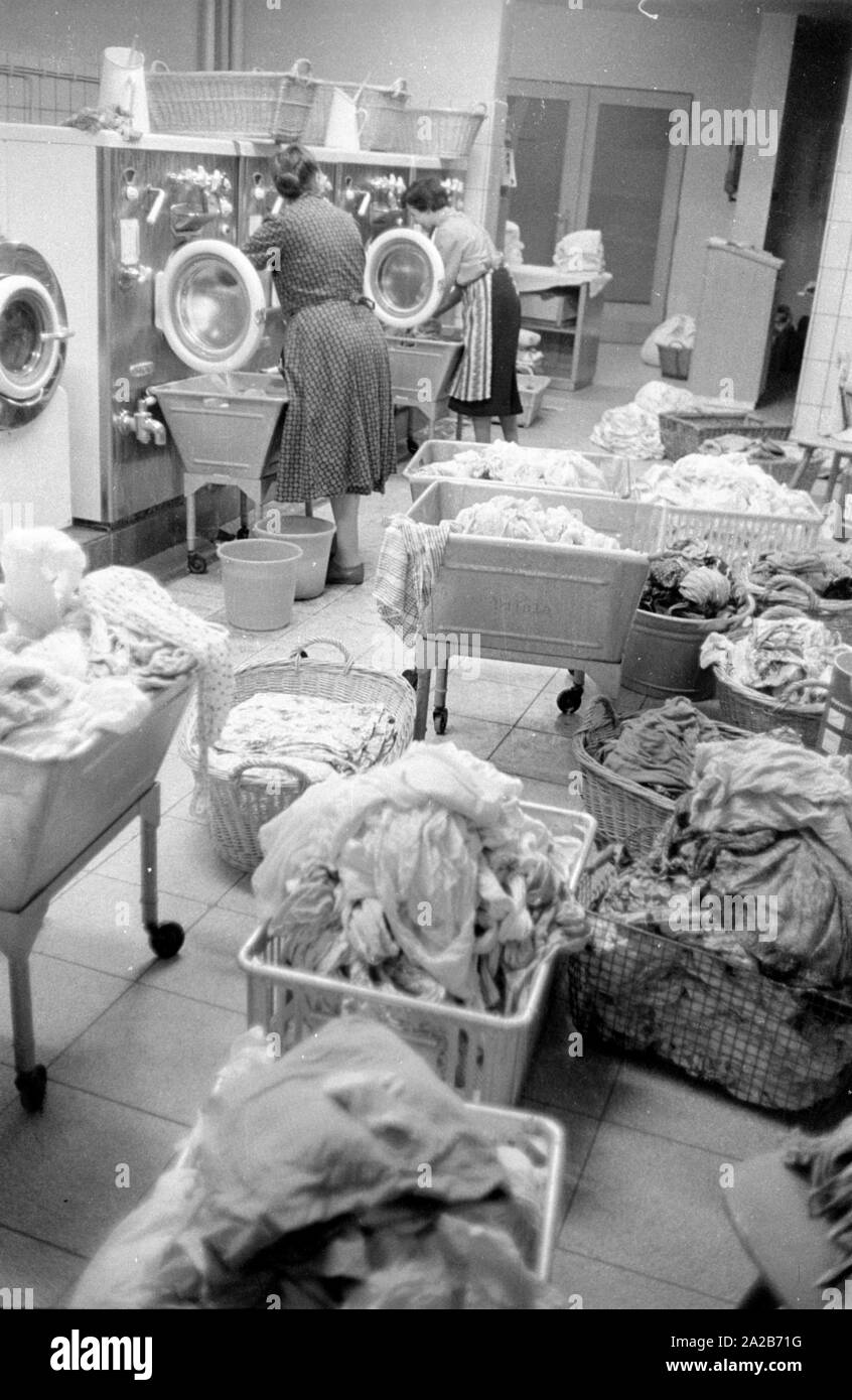 Two women work in the laundry in the village community house in Rimbach. The village community houses were built as part of the Hessenplan among others to improve the infrastructure and cultural life in rural areas. Stock Photo