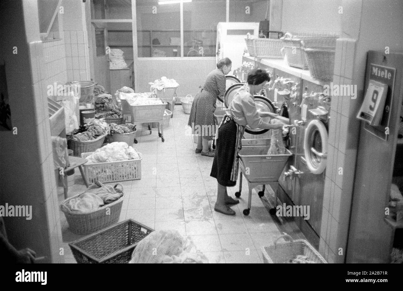 Two women work in the laundry in the village community house in Rimbach. The village community houses were built as part of the Hessenplan among others to improve the infrastructure and cultural life in rural areas. Stock Photo