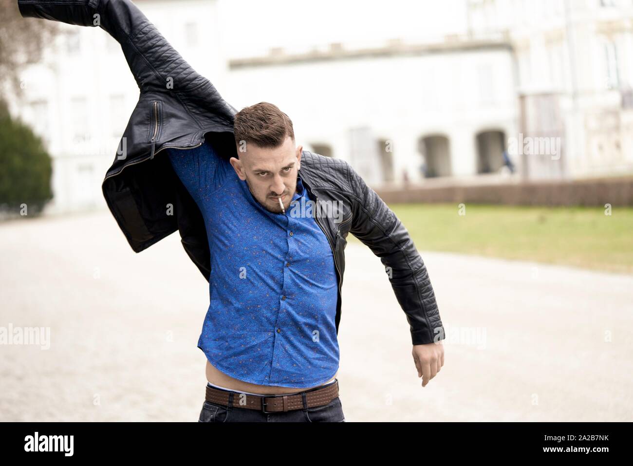 Man in blue shirt putting on Black leather jacket, Munich, Germany Stock  Photo - Alamy