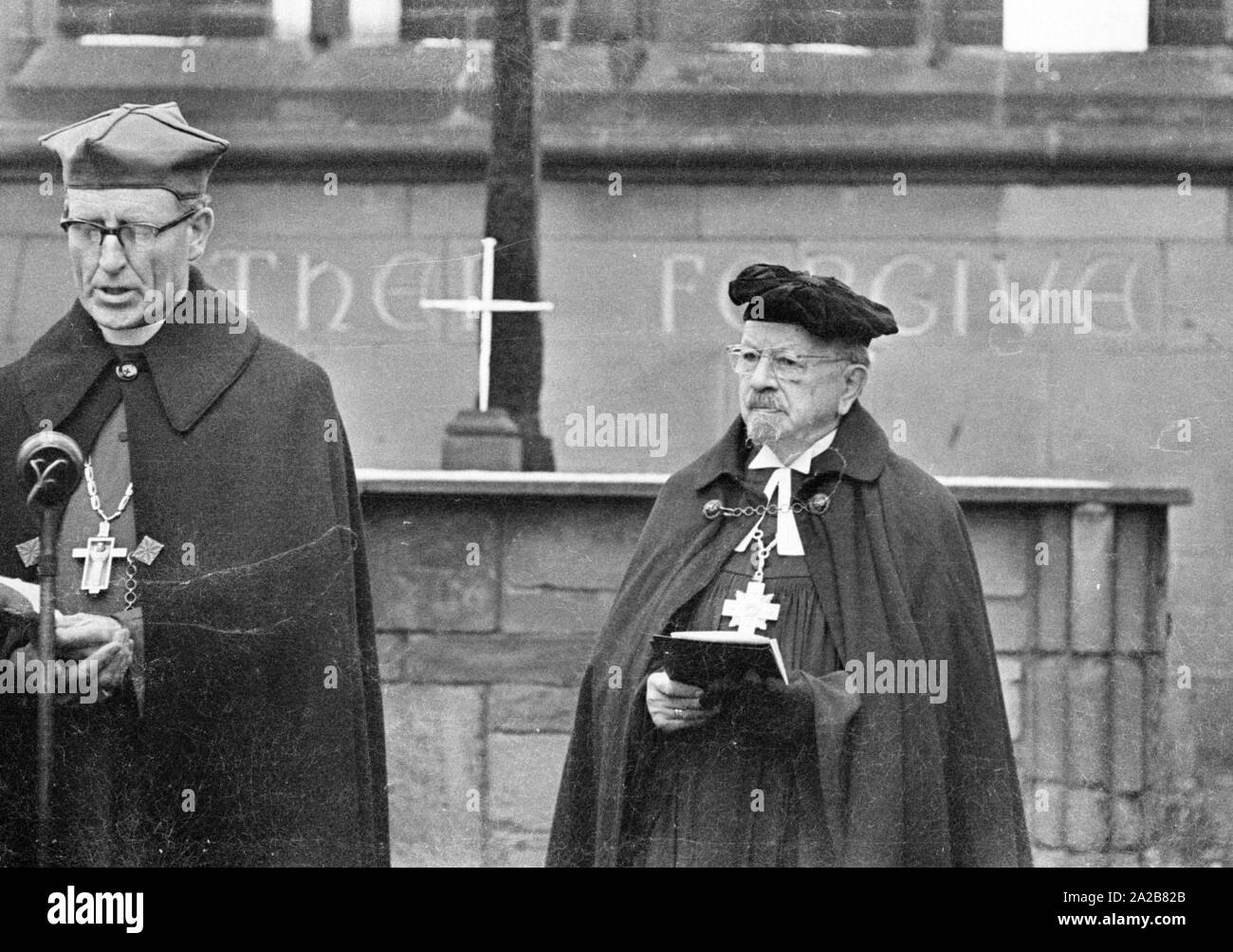 The German bishop, Otto Dibelius (right), participates at the groundbreaking ceremony  of the 'International Center for Reconciliation' in the ruin of the destroyed St Michael's Cathedral. Behind him on the altar, the Cross of Nails as a sign of reconciliation. Stock Photo