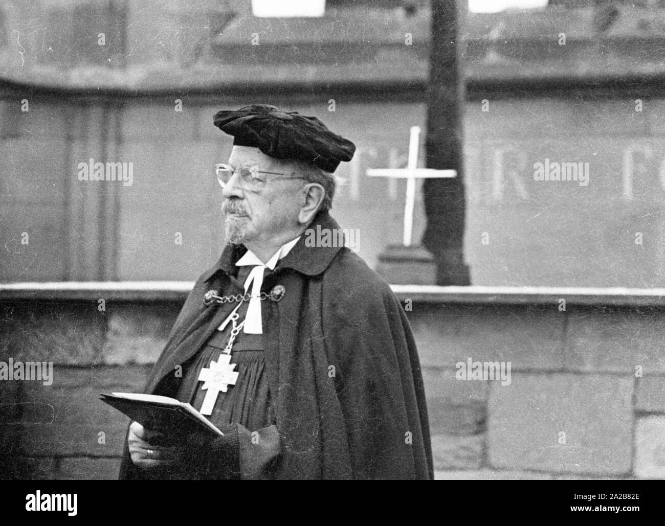 The German bishop, Otto Dibelius, participates at the groundbreaking ceremony  of the 'International Center for Reconciliation' in the ruin of the destroyed St Michael's Cathedral. Behind him on the altar, the Cross of Nails as a sign of reconciliation. Stock Photo