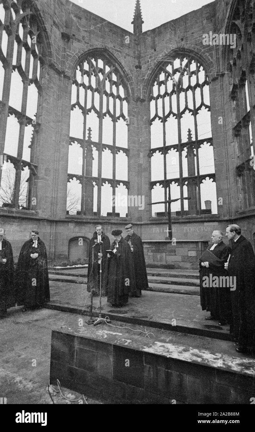 The German bishop, Otto Dibelius, gives a speech in the ruin of the Coventry Cathedral (Cathedral Church of St Michael) on the occasion of the laying of the foundation stone for the 'International Center for Reconciliation' in the same place. Behind him on the left, Reverend Bill Williams, the pastor of Conventry. In the background on the altar, the Charred Cross and the Cross of Nails. Stock Photo