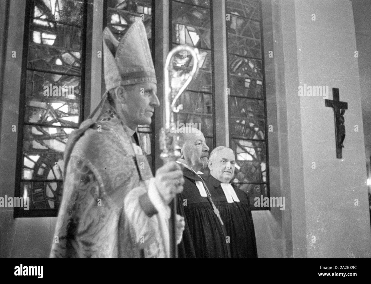 The German bishop, Otto Dibelius, participates at the groundbreaking ceremony  of the 'International Center for Reconciliation' in the ruin of the destroyed St Michael's Cathedral. To his left, a representative of the Church of England. Stock Photo