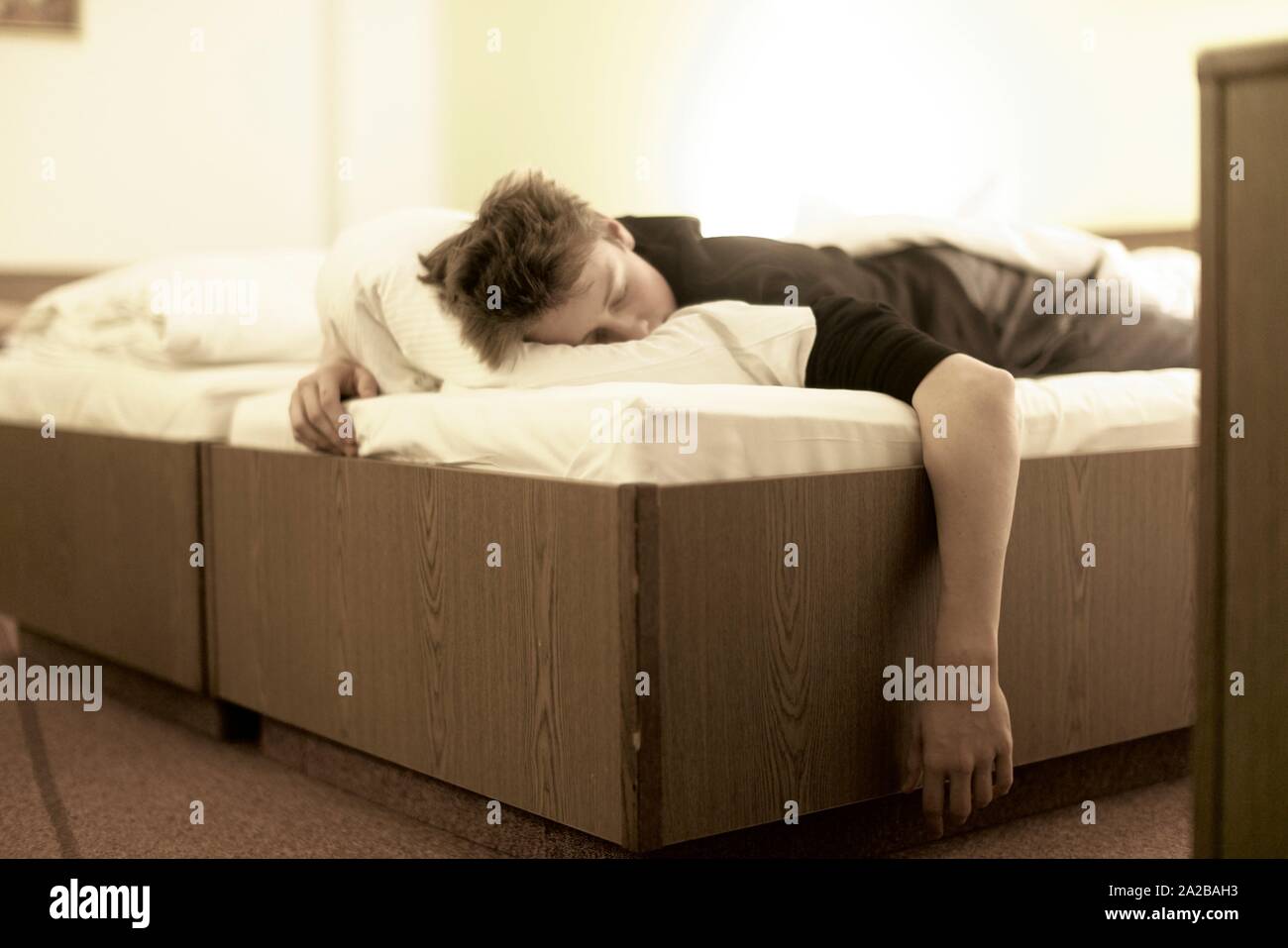 exhausted teenager (17 years) sleeping in bed, in Germany Stock Photo