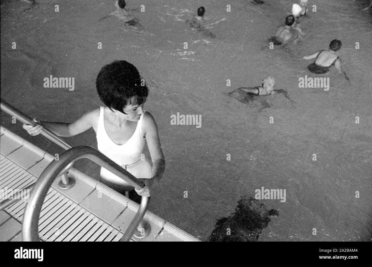 A woman in a white bathing suit gets into the pool Stock Photo Alamy