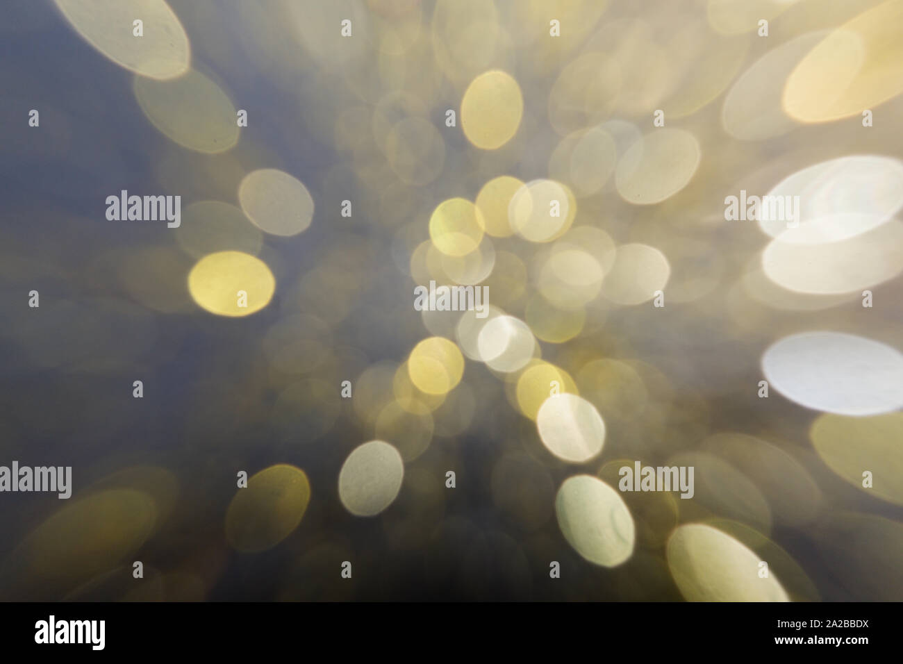 Abstract blurred glitter bokeh background in gold, motion effect, on black Stock Photo