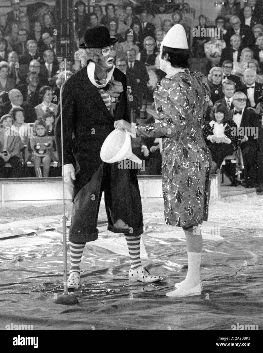 Clowns perform a classic clown act with a funnel in the TV show 'Stars in the Manege' in 1971. Stock Photo