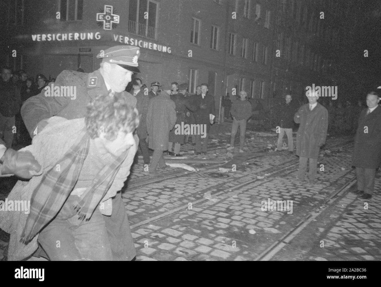 After the assassination attempt on Rudi Dutschke, actions took place against the Springer publishing house throughout Germany on the Easter weekend 1968. In Munich, demonstrators try to stop the delivery of the Bild-Zeitung through the barricade of the Munich bookshop on Schellingstrasse (either 12.04 or 15.04.). In the picture: policemen lead away a demonstrator. Stock Photo