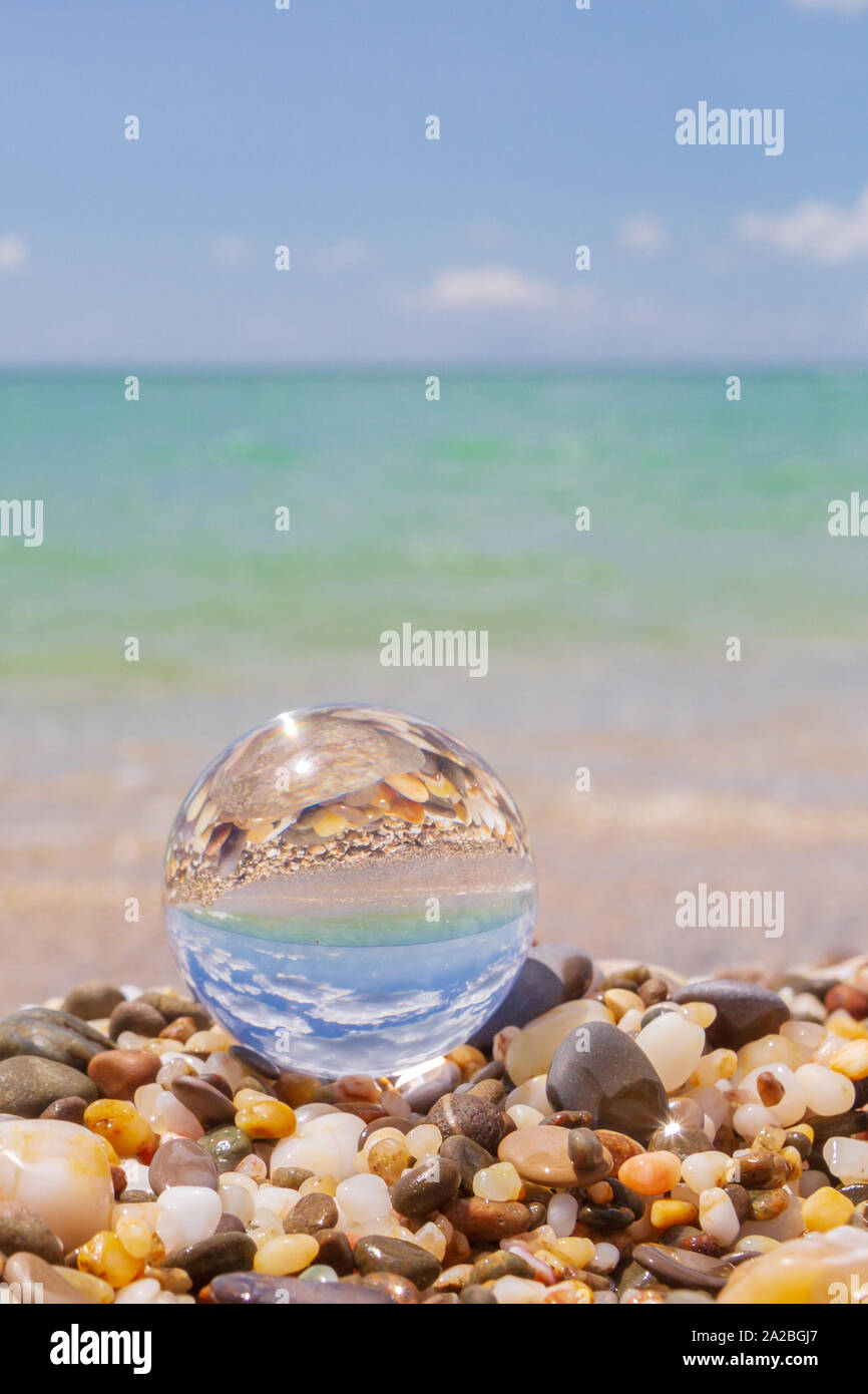 Glass round ball on the beach reflects the sea in summer Stock Photo ...
