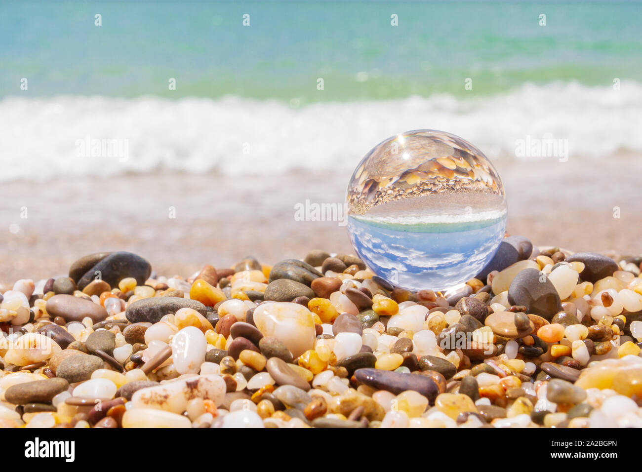 Glass round ball on the beach reflects the sea in summer Stock Photo ...