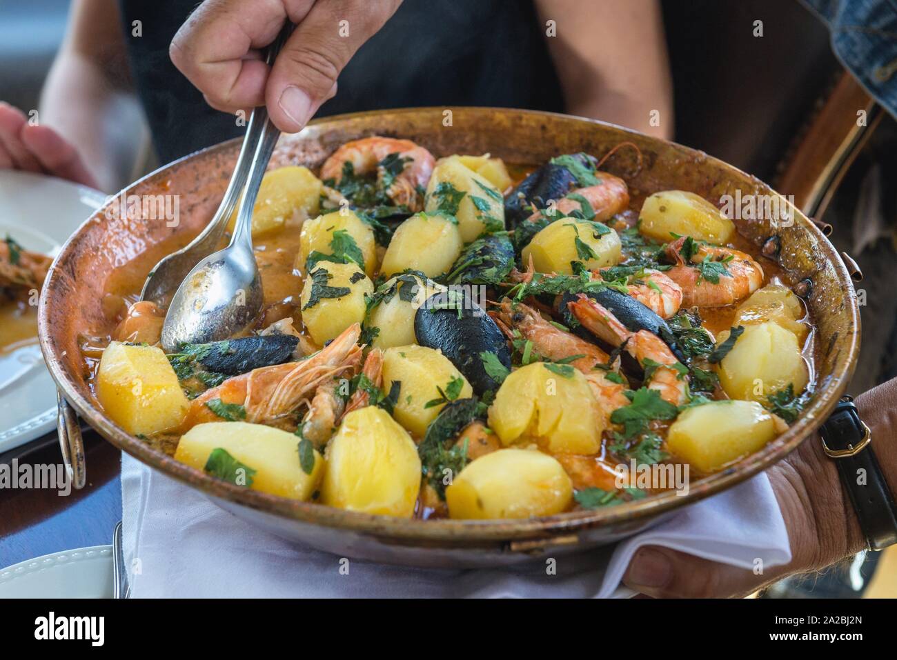 Traditional Portuguese stew with potatoes and mixture of sea food Stock