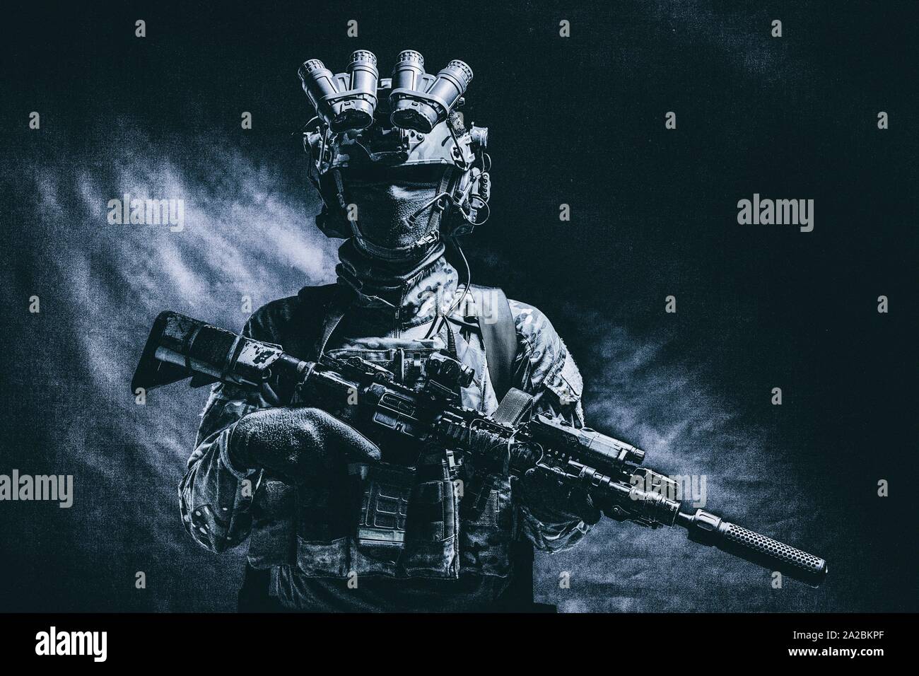 Half length, low key studio shoot of army soldier, marine infantryman in mask, camo uniform, equipped modern ammunition, armed service rifle standing Stock Photo