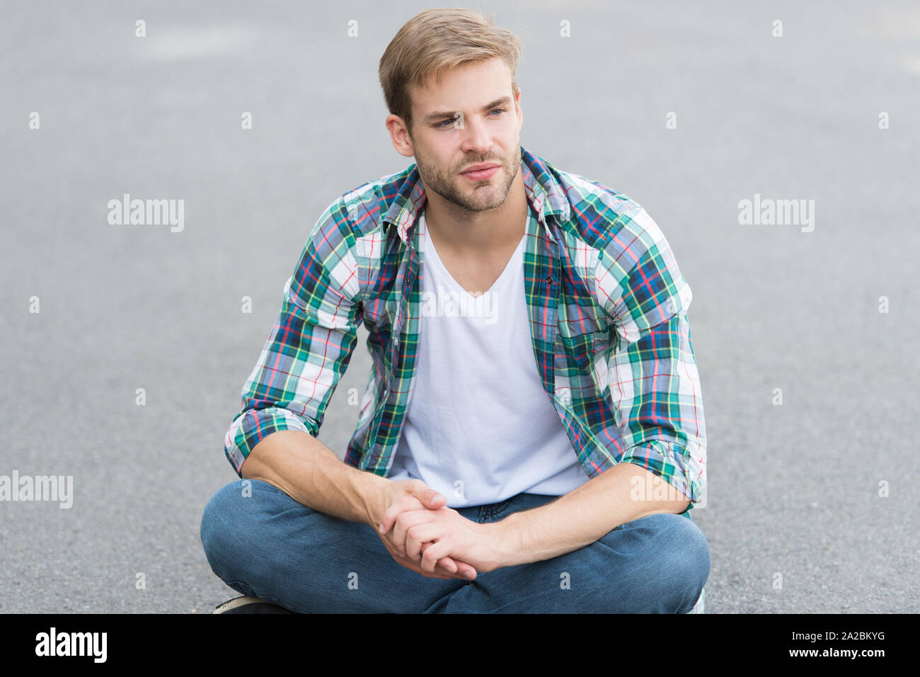 i have free time. male fashion. student relax on road. macho guy outdoor.  street style. man sit ground. carefree student guy. free time spending. summer  fashion. handsome man checkered shirt Stock Photo -