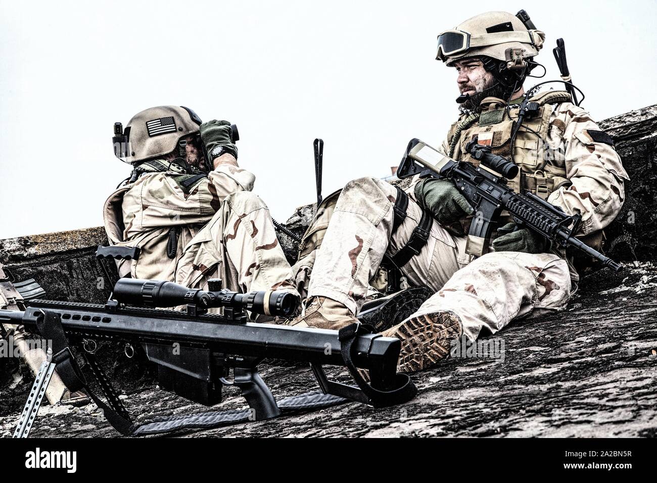 U. S. Navy SEAL infantrymen, commando marksman in battle uniform, armed with assault service rifle with optics sight, observing territory while Stock Photo