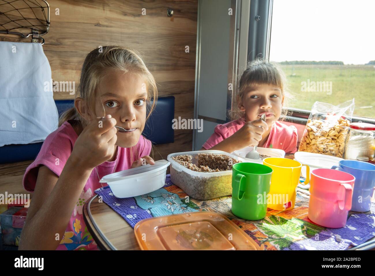 Two girls eat on the train Stock Photo Alamy