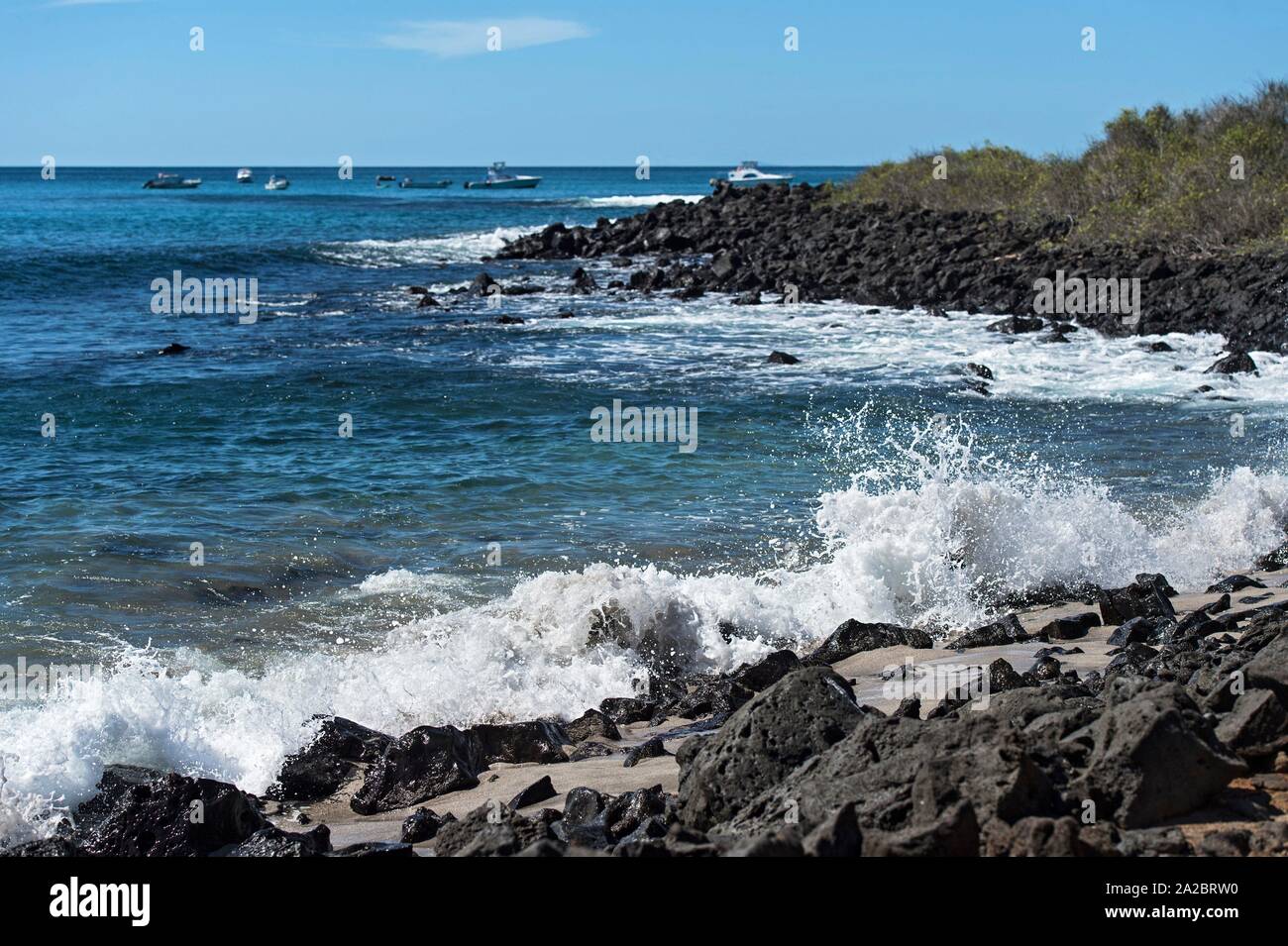 Waves breaking at the lava rocks of the coast, Floreana Island, Galapagos Islands, Ecuador. Stock Photo