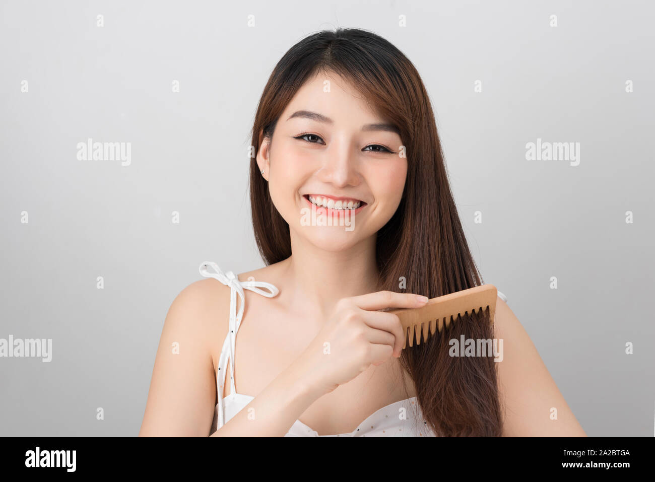 Portrait of a Beautiful Young Asian Female - combing her long straight hair Stock Photo
