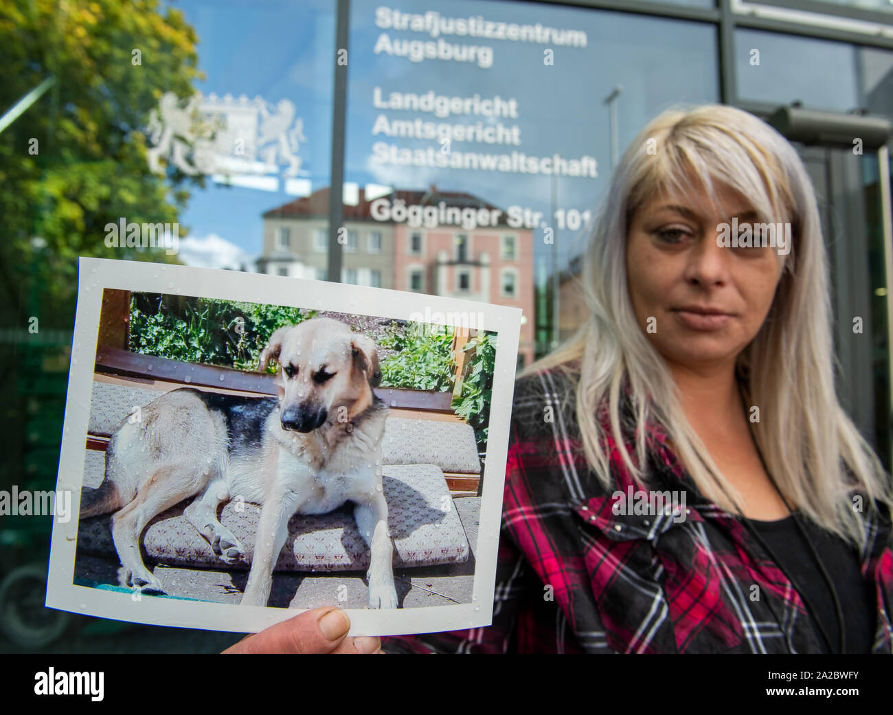 Augsburg, Germany. 02nd Oct, 2019. Judith Jamesson stands with a photo of her dog Maja before the criminal court building. According to a hunter Maja poached together with another dog and shot both dogs before the eyes of the owner. He was sentenced to 90 daily rates for damage to property, punishable animal slaughter and negligent bodily injury. Credit: Stefan Puchner/dpa/Alamy Live News Stock Photo