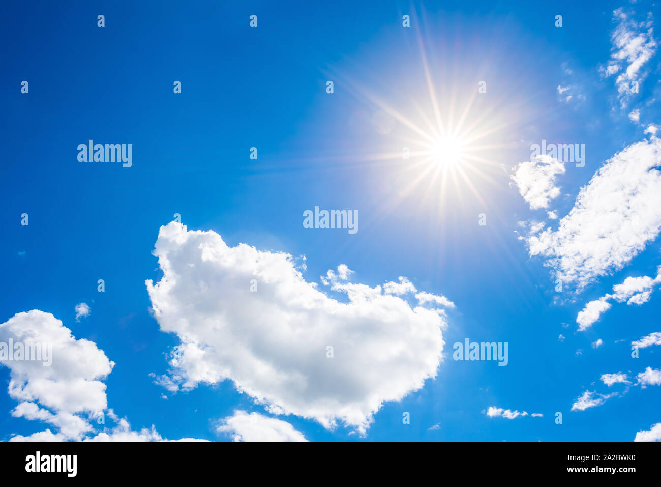 Sunny background, blue sky with white clouds and sun Stock Photo