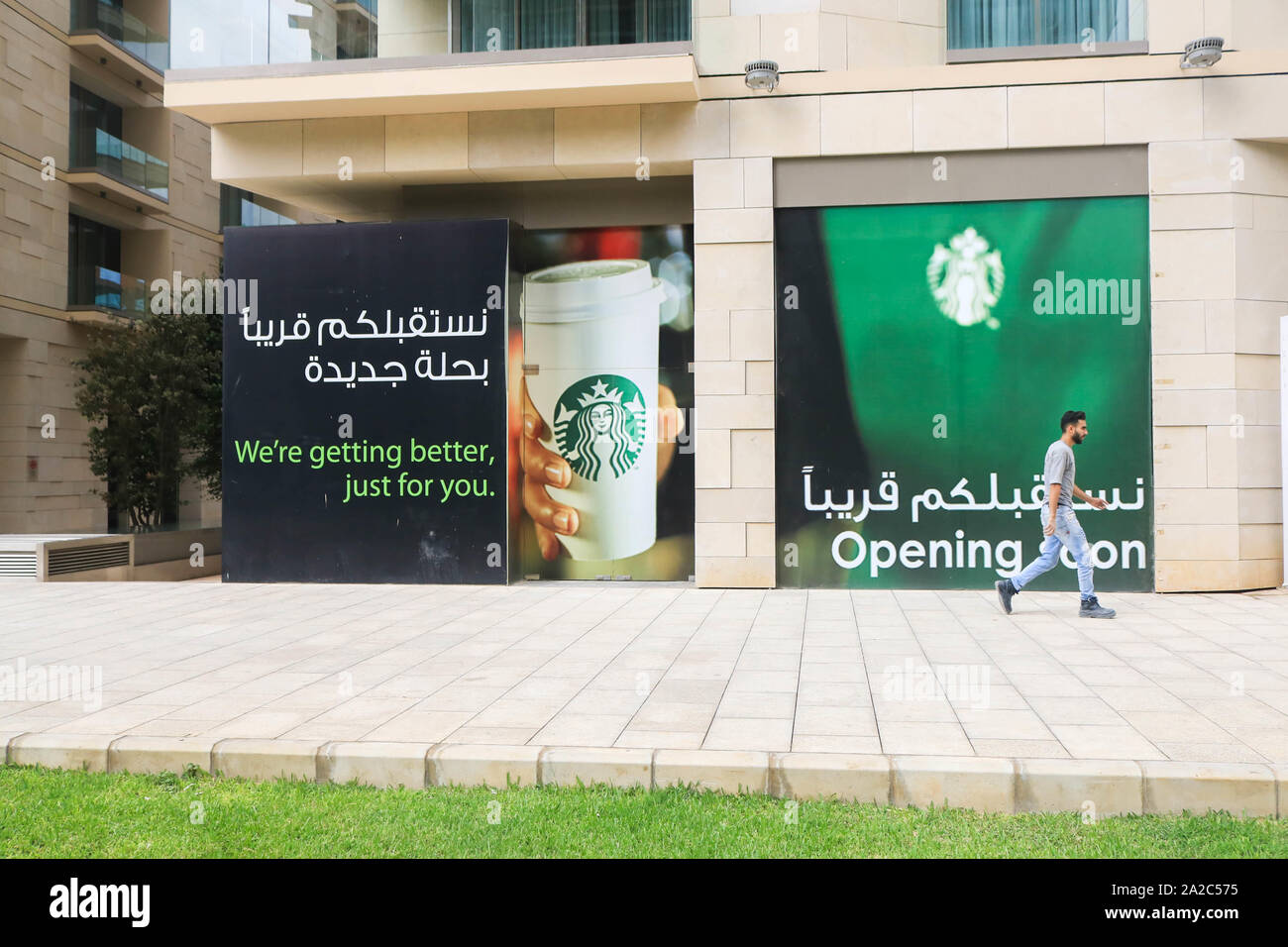 Beirut, Lebanon - 02 October 2019. A pedestrian walks past a poster in Arabic language adverstising  the opening of a new Starbucks coffeehouse in downtown Beirut Credit: amer ghazzal/Alamy Live News Stock Photo