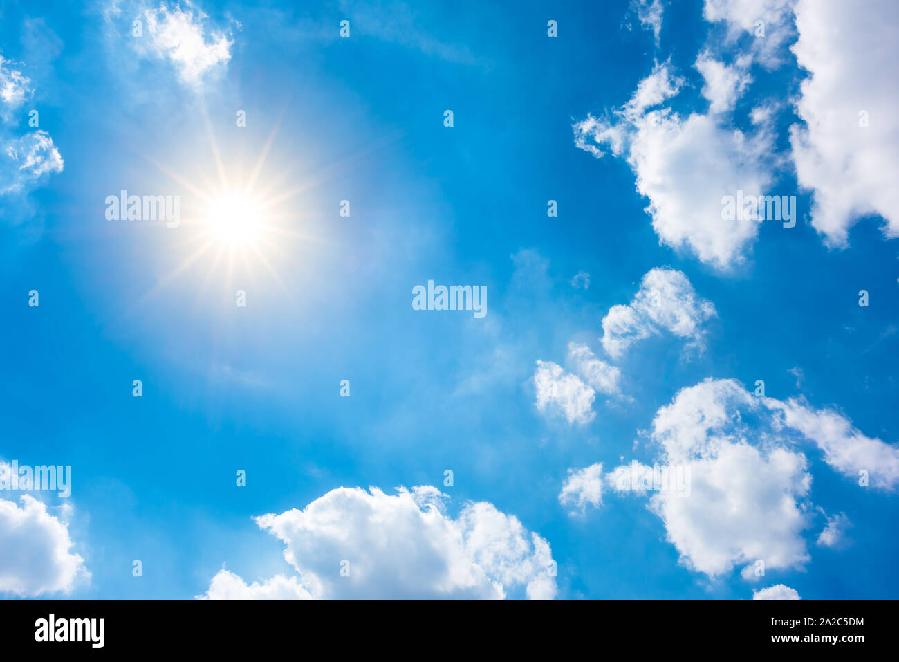 Sunny background, blue sky white clouds and bright sun Stock Photo