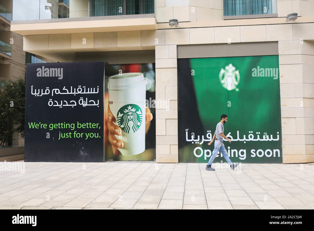Beirut, Lebanon - 02 October 2019. A pedestrian walks past a poster in Arabic language adverstising  the opening of a new Starbucks coffeehouse in downtown Beirut Credit: amer ghazzal/Alamy Live News Stock Photo