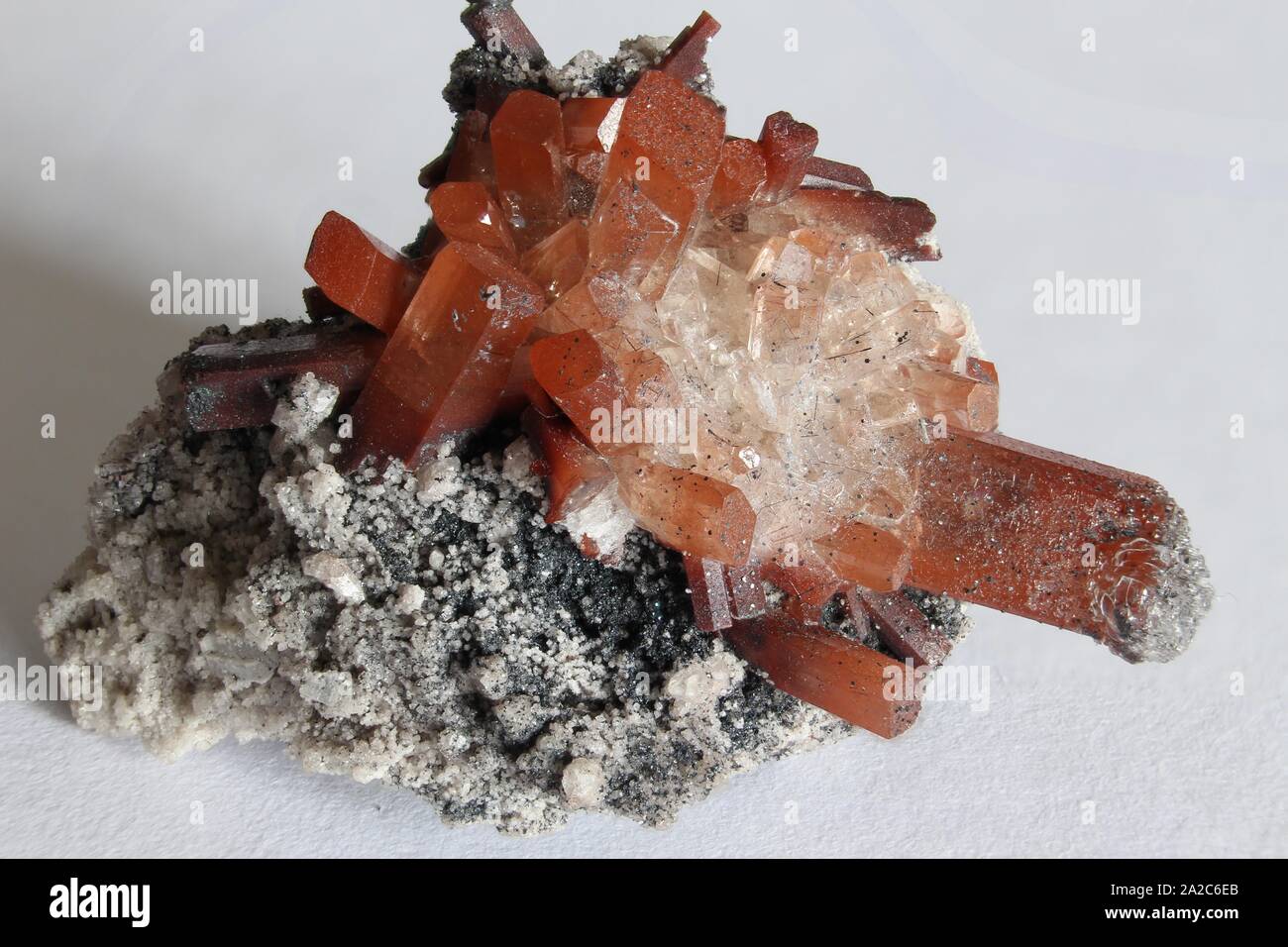 Rock matrix with small crystals and orange and clear topaz with white  background Stock Photo - Alamy