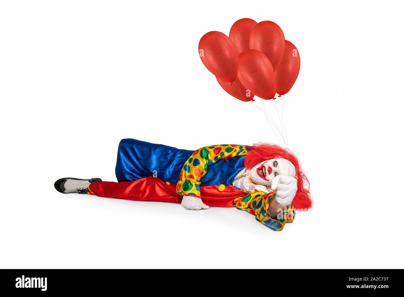 клоун лежит. клоун лежит. клоуна лежит на столе. клоун валяется. цирк клоун лежащий.