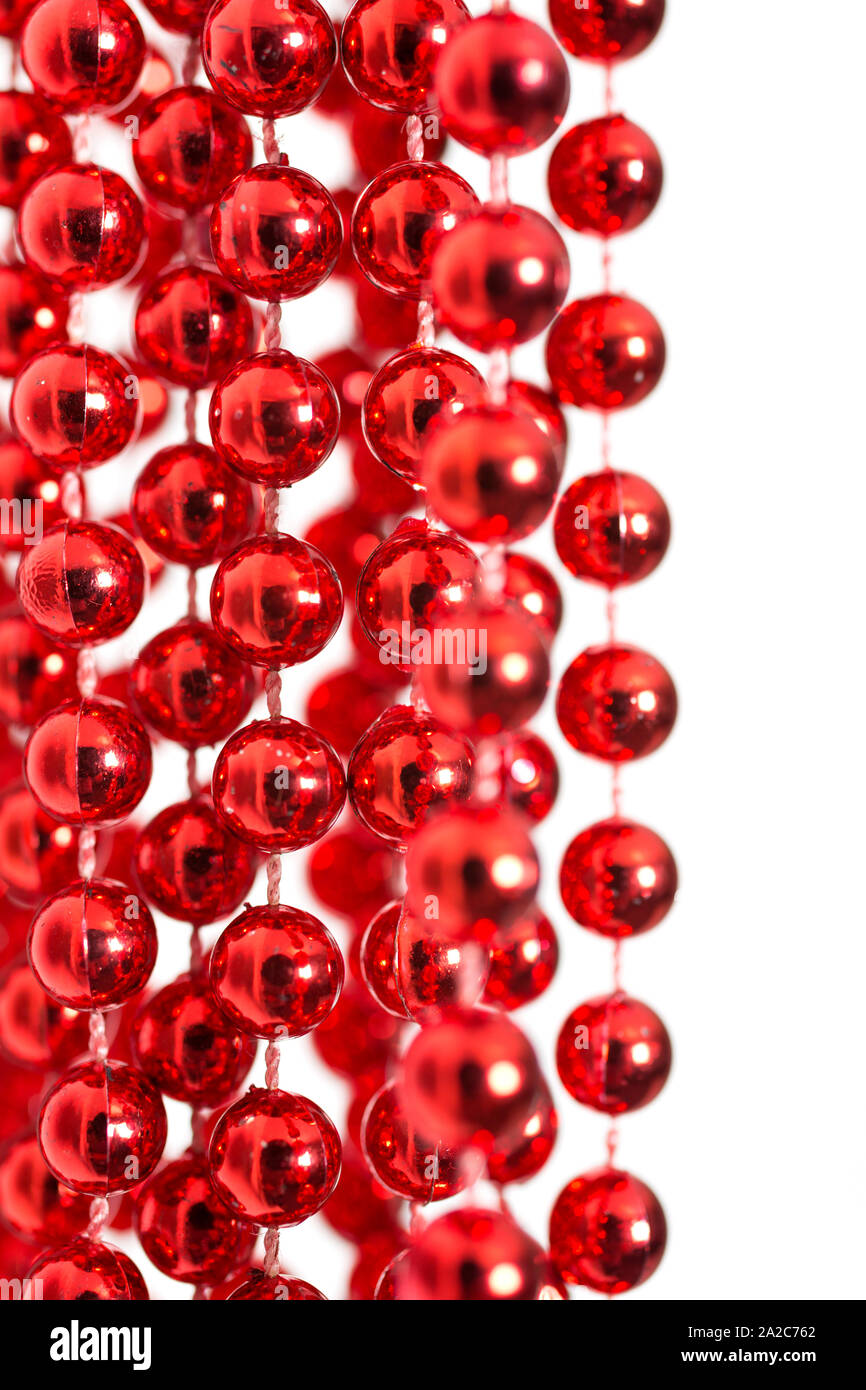 Vibrant red decorative beads handing against an isolated white