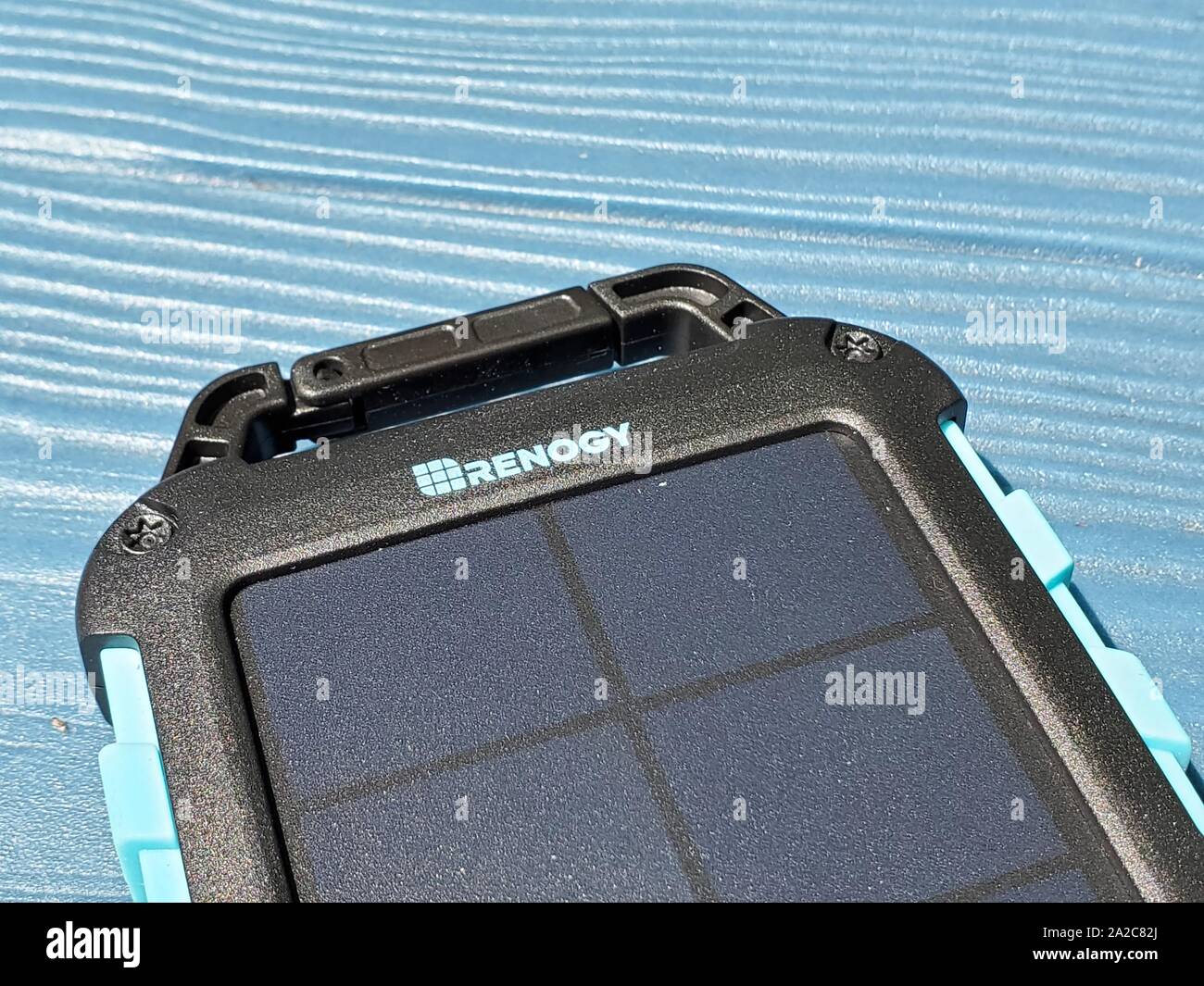 Renogy EPower solar-powered emergency cellular phone charger, designed for use during camping or power outages, charging in sunlight on a blue surface outdoors, San Ramon, California, August 2, 2019. () Stock Photo