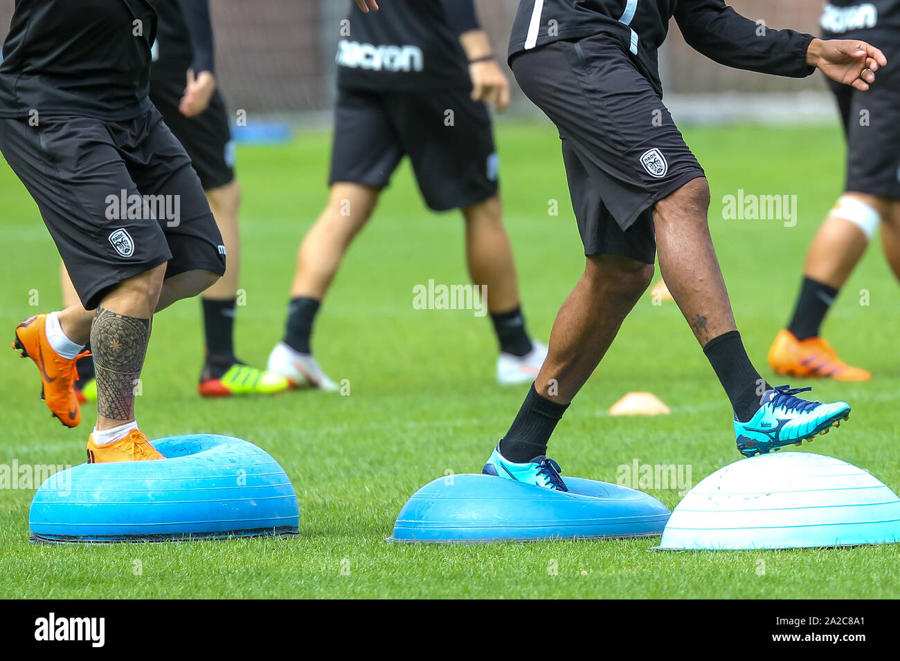 Horst, Netherlands - June 25, 2018: The feet of PAOK players and football training equipment during the training of the team on the pitch. balance exe Stock Photo