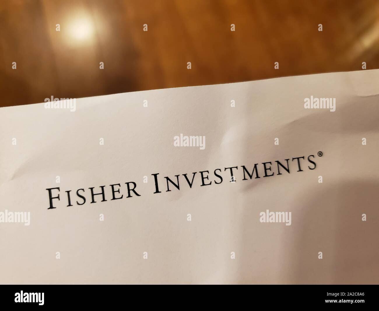 Close-up of logo for financial management company Fisher Investments on paper on light wooden background, August 29, 2019. () Stock Photo