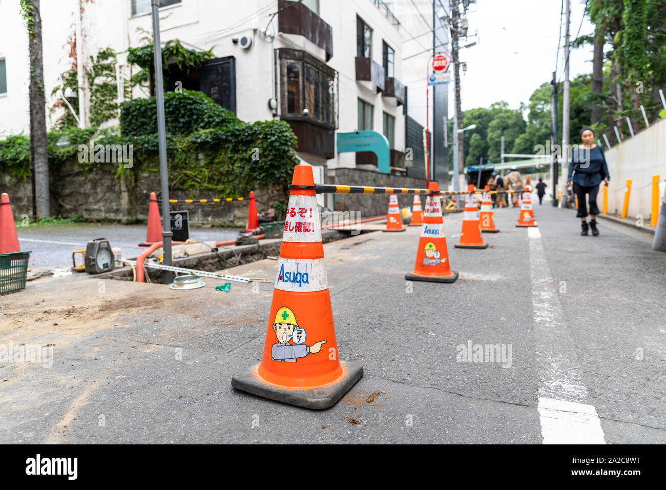 Traffic cones around construction work on small street in Tokyo, Japan Stock Photo