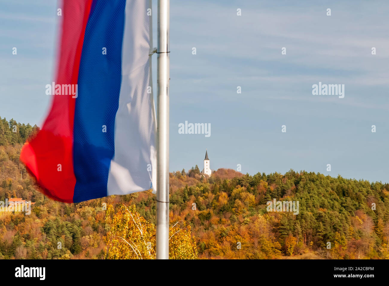 The flag of Slovenia flies against a beautiful autumn background in Zrece Stock Photo