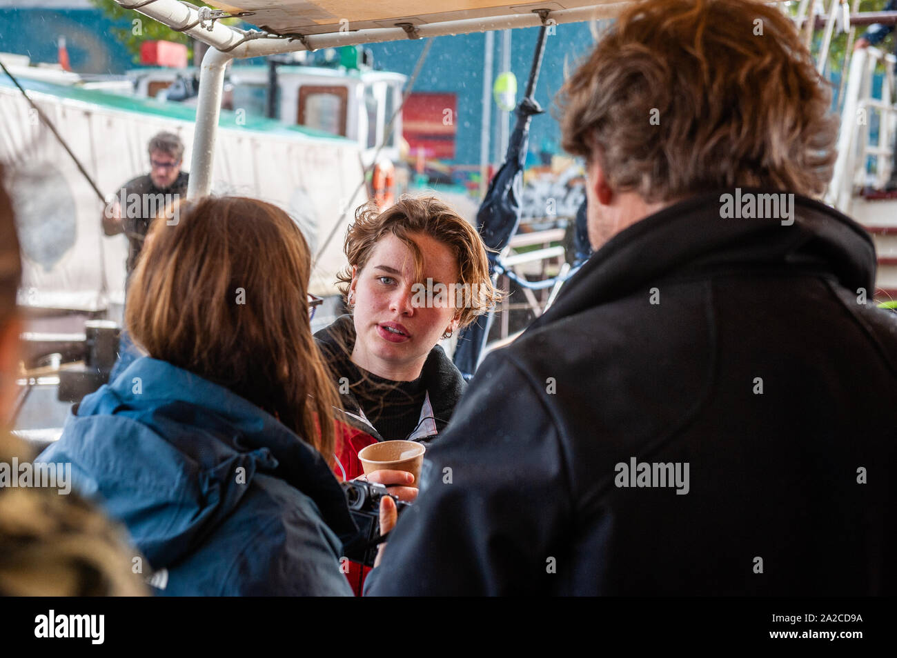 Belgian climate activist, Anuna de Weber talks to her family on the boat.From the NDSM Wharf in Amsterdam, 36 climate activists are sailing out to go to the UN Climate Conference in Santiago, Chile. Between them, there is Anuna de Weber, who is the organizer of the Climate Strikes in Belgium and Adélaïde Charlier, French-speaking coordinator for the 'Youth for climate' movement. Their mission as Greta Thunberg already did, is decrease the climate impact of traveling. They will be sailing for around 7 weeks to Rio de Janeiro, and from there they will travel by bus. Stock Photo