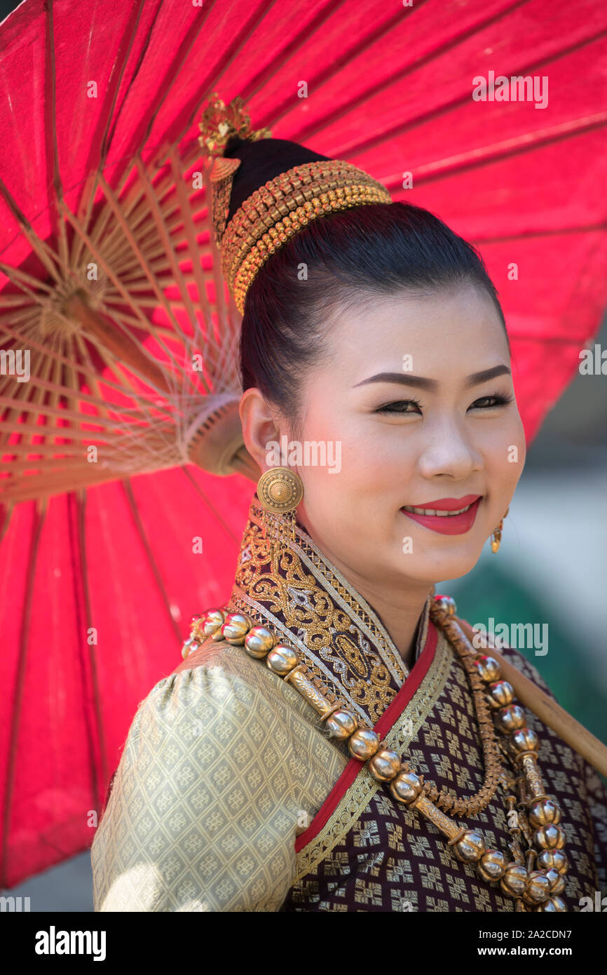 Young Laos woman in traditional outfit with red umbrella, Luang Prabang ...