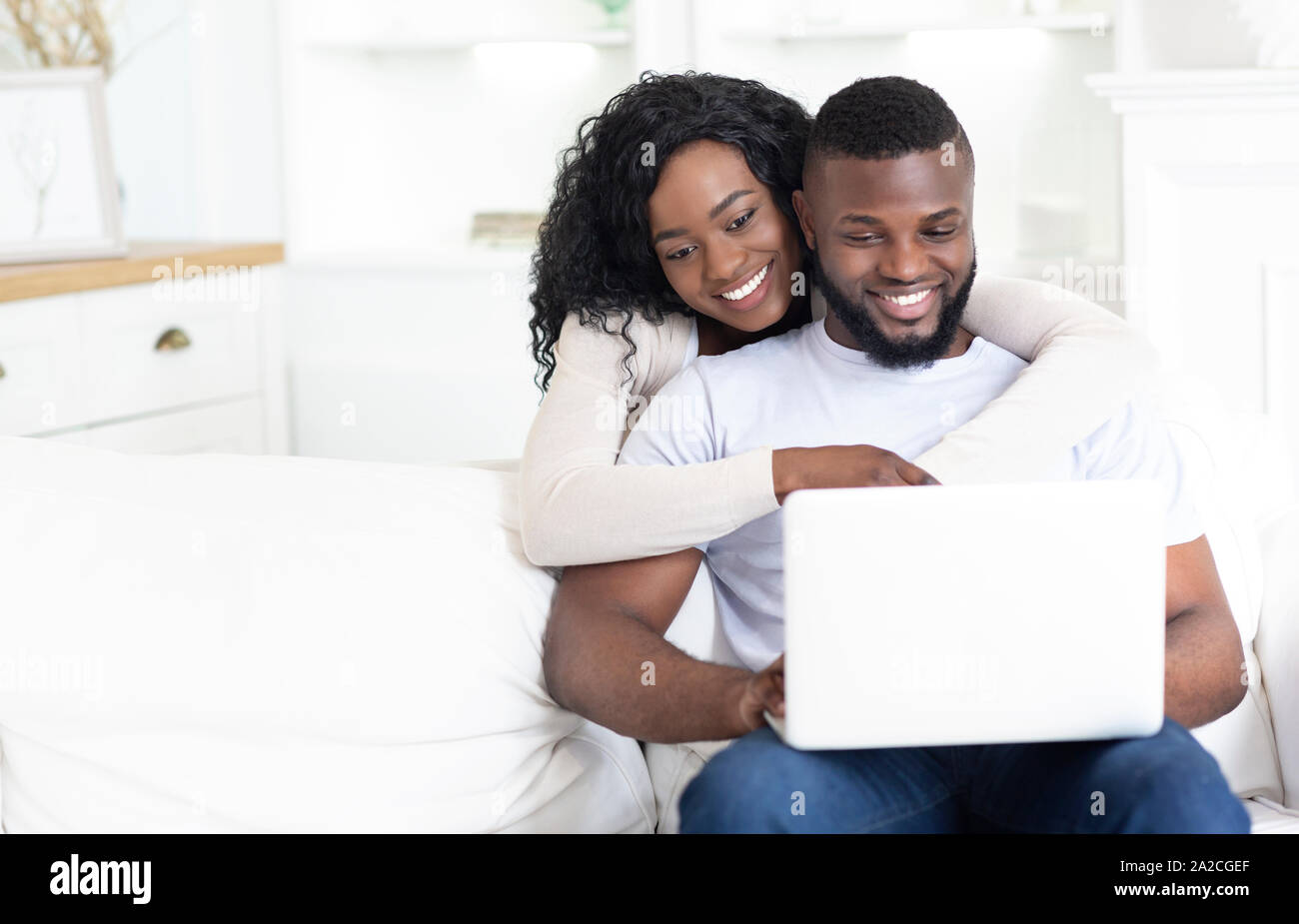 Happy African American couple using laptop together at home Stock Photo ...