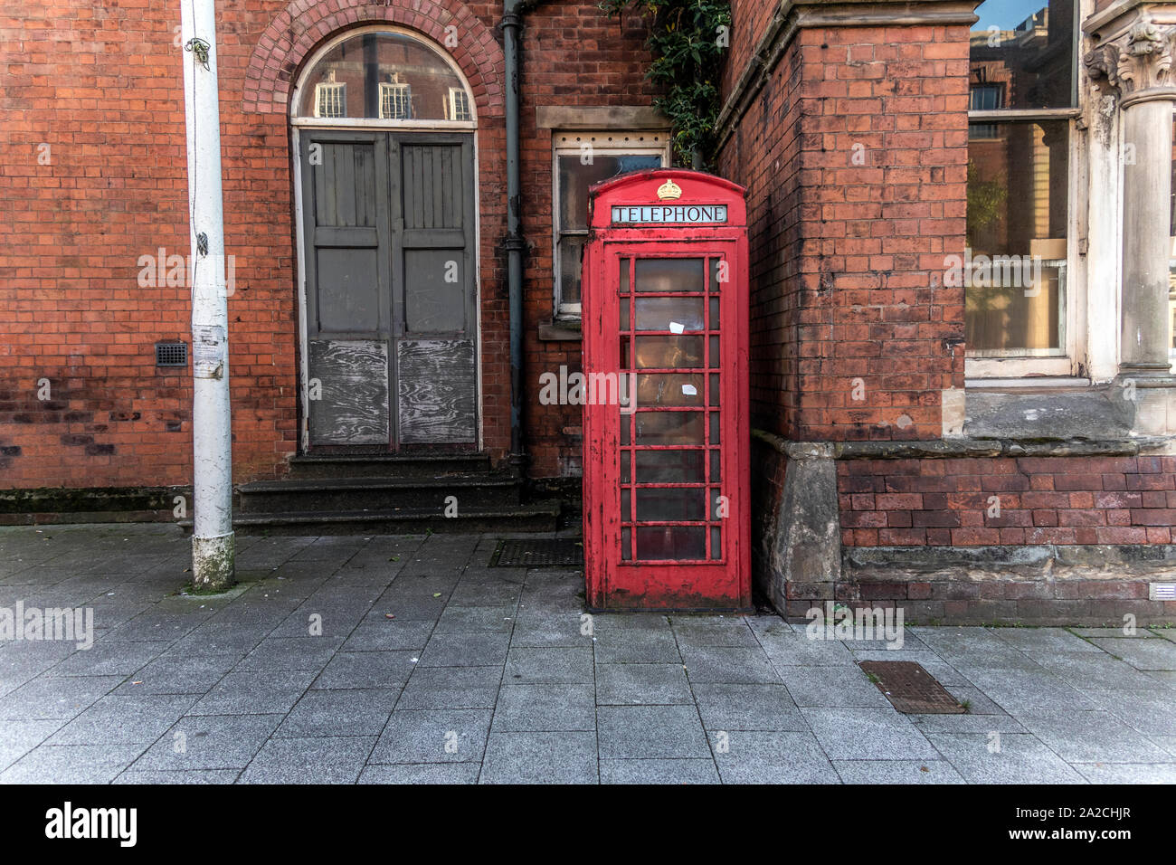 Old fashioned telephone box. In a rundown area of West Bromwich, West Midlands, UK. Stock Photo