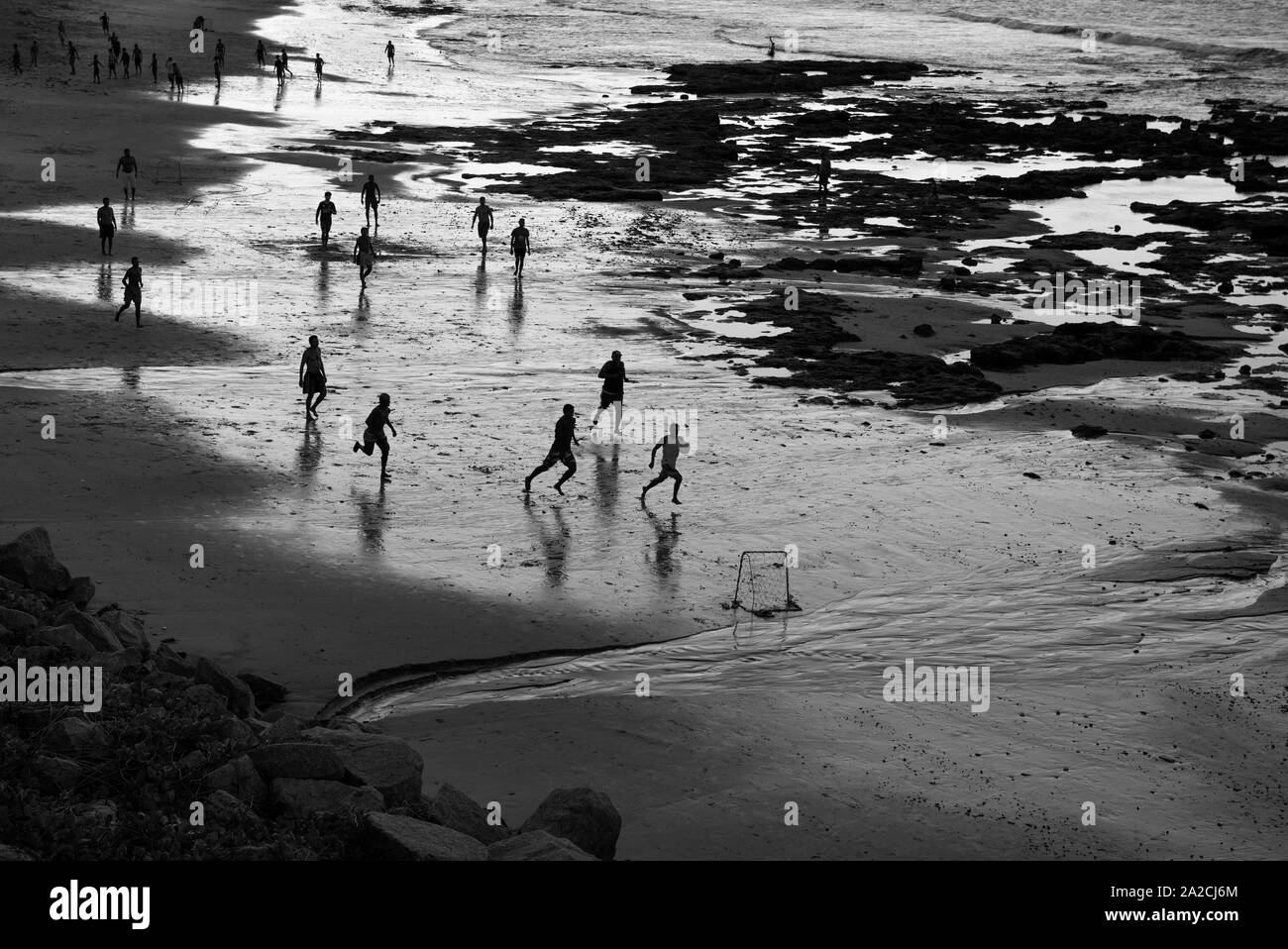 People playing soccer in the beach Stock Photo