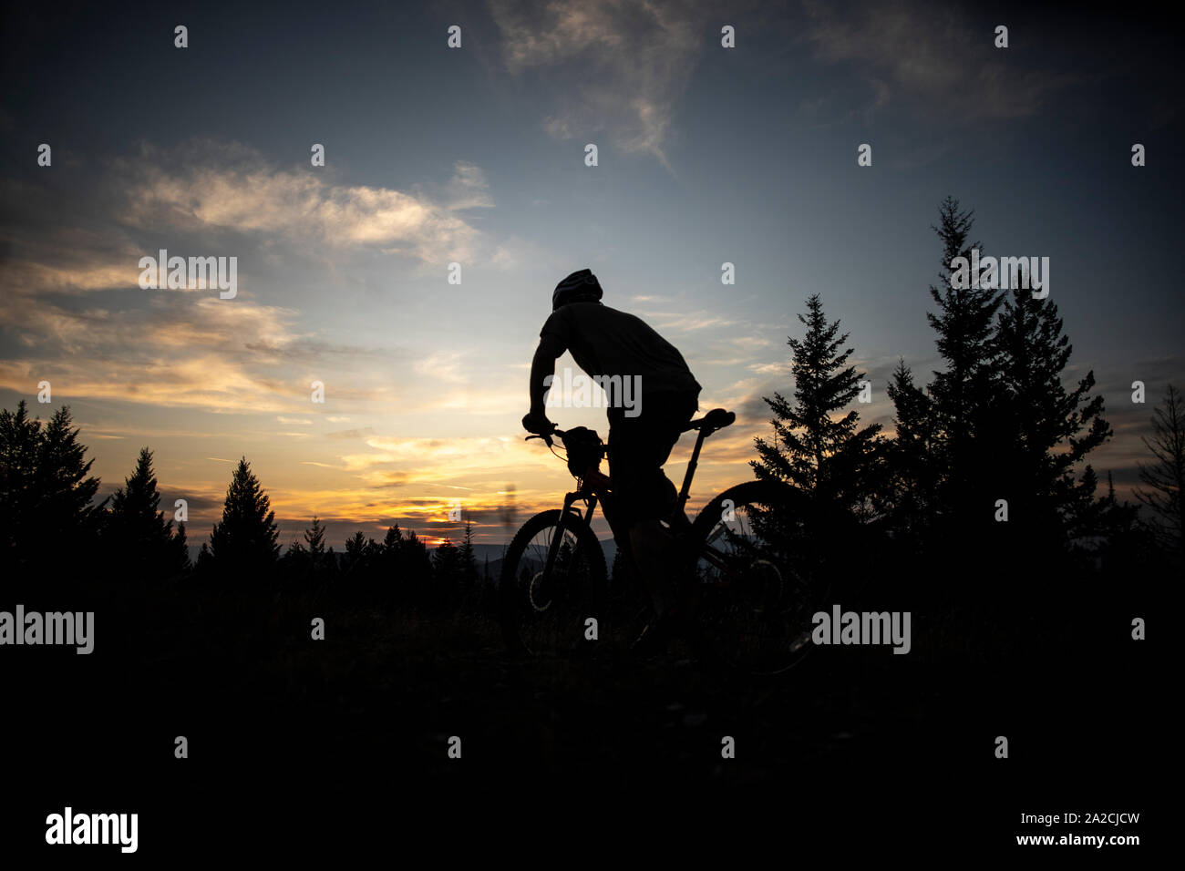 A mountain biker rides towards the sunset on  top ofBlue Mountain Stock Photo